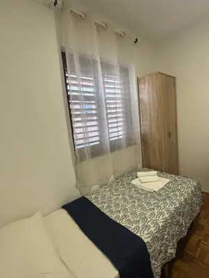a small bedroom with a bed and a window at Bloom Home Bar in Bar