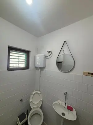 a bathroom with a toilet and a sink and a mirror at Bloom Home Bar in Bar
