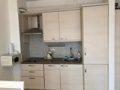 a kitchen with white cabinets and a sink at Seaview apartment in Dobra Voda