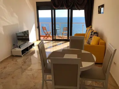 a living room with a dining table and a television at Seaview apartment in Dobra Voda