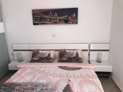 a small bedroom with a bed with a bridge picture on the wall at Seaview apartment in Dobra Voda