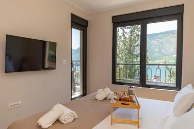 a bedroom with a bed with a flat screen tv at Villa Teona KotorBay Residence in Kotor