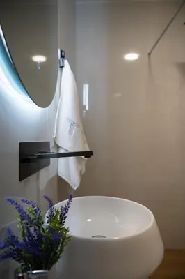 a bathroom with a white sink and a towel at Villa Teona KotorBay Residence in Kotor