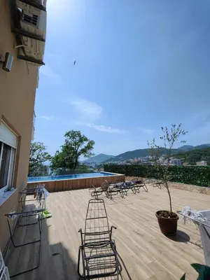 a patio with chairs and a tree on a building at Rafailovići Hill in Budva