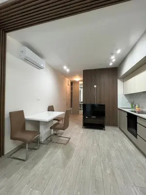 a kitchen and living room with a table and chairs at FAB LIFE Becici in Becici