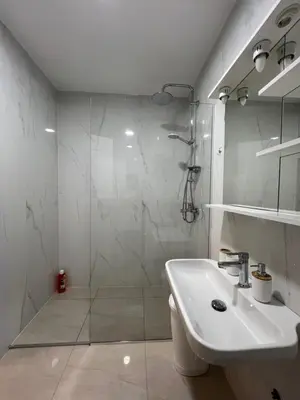 a white bathroom with a shower and a sink at FAB LIFE Becici in Becici