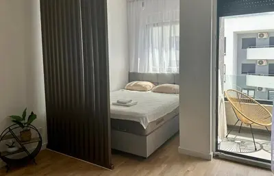 a small bedroom with a bed and a window at Apartment Lule in Bar