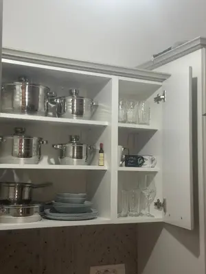 a kitchen cabinet with pots and pans and plates at Apartment Lule in Bar