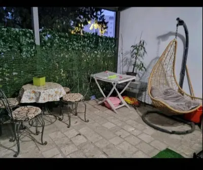 a patio with a table and chairs and a hammock at Apartman Duki in Budva