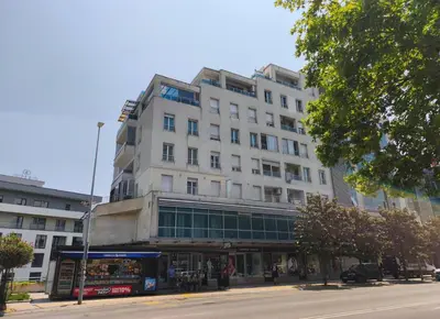a tall white building on a city street at Kraljev park in Podgorica