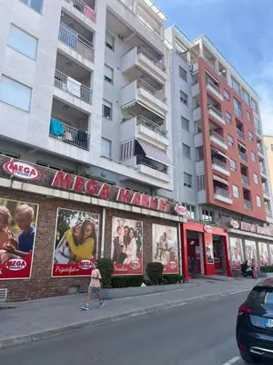 a girl walking down a street in front of a building at Apartman Mega Budva in Budva