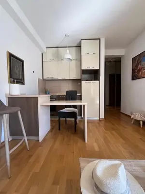 a living room with a desk and a kitchen at Apartman Mega Budva in Budva
