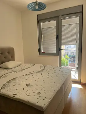 a large bed in a room with a window at Apartman Mega Budva in Budva