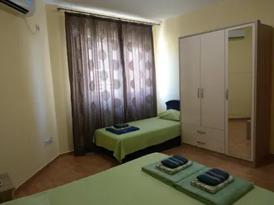 a bedroom with two beds and a large window at Apartment Barski in Bar
