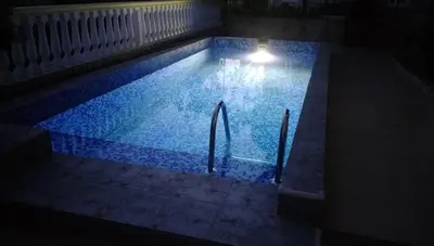 a swimming pool at night with a light in it at Apartment Barski in Bar