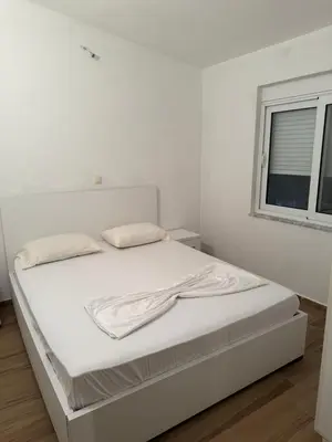a white bed in a white room with a window at Bregvija Apartments in Donji Štoj