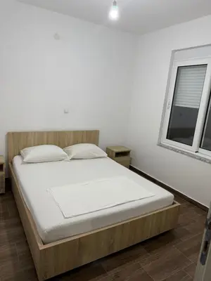 a bed in a white room with a window at Bregvija Apartments in Donji Štoj
