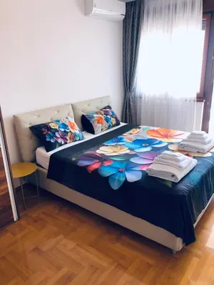 a bedroom with a bed with a floweridered blanket at Anatolia Luxury Seaview Residence in Becici