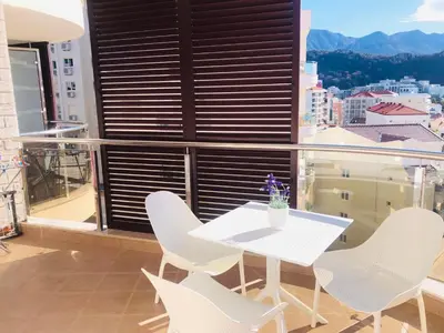 a white table and chairs on a balcony with a view at Anatolia Luxury Seaview Residence in Becici