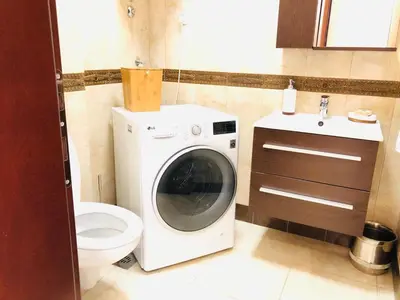 a bathroom with a washing machine and a toilet at Anatolia Luxury Seaview Residence in Becici