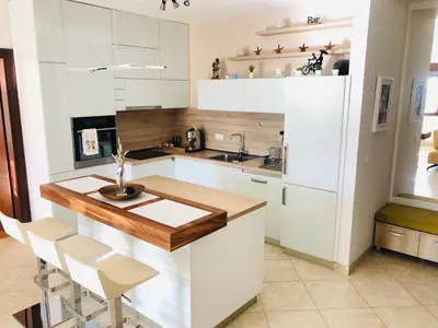 a kitchen with white cabinets and a wooden counter top at Anatolia Luxury Seaview Residence in Becici