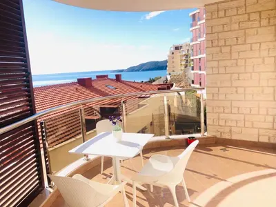 a balcony with a table and chairs and the ocean at Anatolia Luxury Seaview Residence in Becici