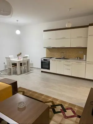 a large kitchen with white cabinets and a table at I&A Apartments in Ulcinj