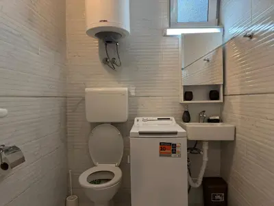 a small bathroom with a toilet and a sink at Sunny Nest Studio Bar in Bar