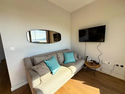 a living room with a couch and a flat screen tv at SeaView Suite with Pool near Tivat Airport by Solea Vacation Homes in Tivat
