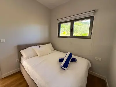 a small bedroom with a bed with a window at SeaView Suite with Pool near Tivat Airport by Solea Vacation Homes in Tivat