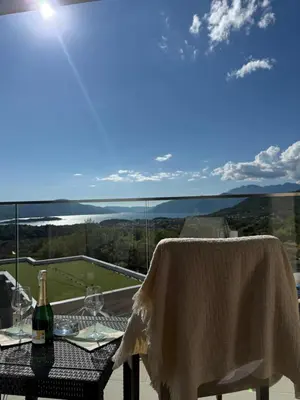 a table with a wine bottle and glasses on a balcony at SeaView Suite with Pool near Tivat Airport by Solea Vacation Homes in Tivat