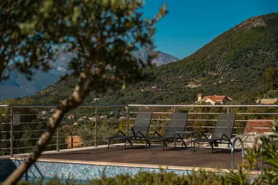 a group of chairs sitting on a deck overlooking a mountain at SeaView Suite with Pool near Tivat Airport by Solea Vacation Homes in Tivat