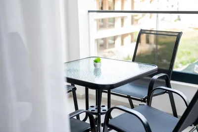 a table and chairs on a balcony with a plant on it at Tarik Apartment in Ulcinj