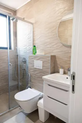a bathroom with a shower and a toilet and a sink at Tarik Apartment in Ulcinj