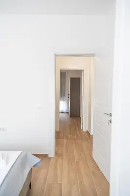 an empty room with white walls and a wooden floor at Tarik Apartment in Ulcinj