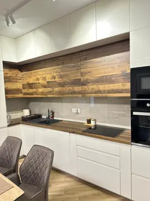 a kitchen with white cabinets and black appliances at Vila Dusan in Bar