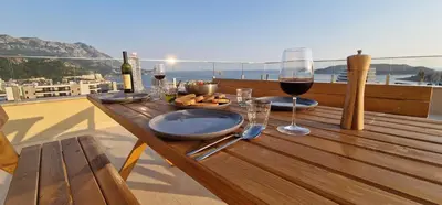 a table with glasses of wine and food on a balcony at Penthouse Traumblick Bečići in Budva