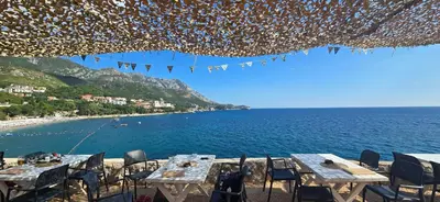 a view of a beach with tables and chairs at Penthouse Traumblick Bečići in Budva