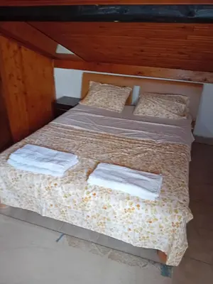 a bedroom with a bed with two white towels on it at REX aprartament in Podgorica