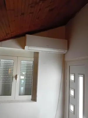 a kitchen with a ceiling fan and two windows at REX aprartament in Podgorica