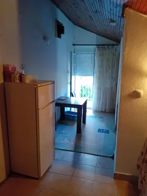 a small kitchen with a table and a refrigerator at REX aprartament in Podgorica