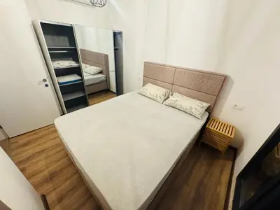a small bedroom with a bed and a mirror at Florida Apartments in Dobra Voda
