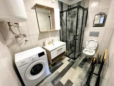 a bathroom with a washing machine and a toilet at Florida Apartments in Dobra Voda