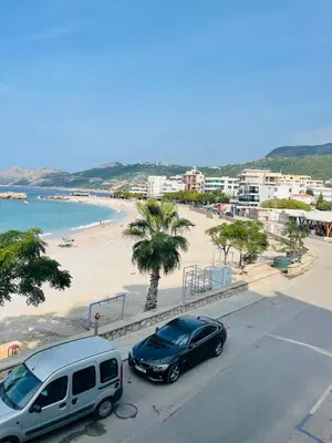 two cars parked on a street next to a beach at Florida Apartments in Dobra Voda