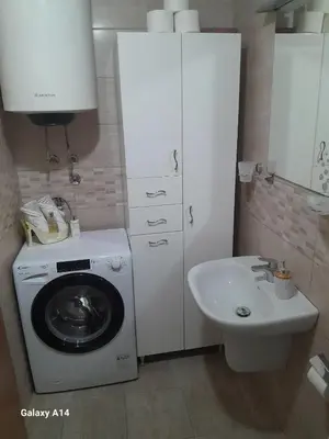 a bathroom with a washing machine and a sink at Apartman Ana in Budva