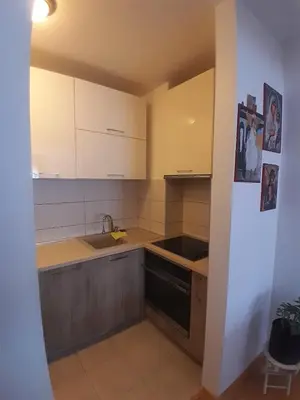 a kitchen with white cabinets and a sink and a stove at Apartman Ana in Budva