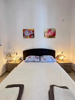 a bedroom with a large white bed with two night stands at Second floor near the Long Beach, Montenegro in Ulcinj