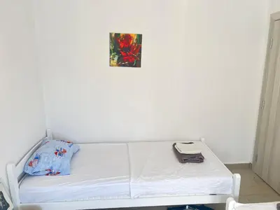 a white bed in a room with a picture on the wall at Second floor near the Long Beach, Montenegro in Ulcinj
