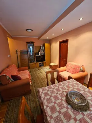 a living room with a table and chairs and a couch at Apartman Orange Budva in Budva