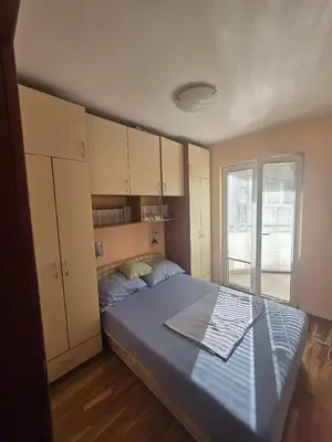 a bedroom with a large bed and a window at Apartman Orange Budva in Budva